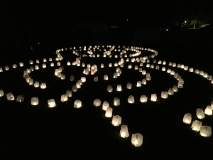 A night labyrinth of candles in recycled water jugs. 
